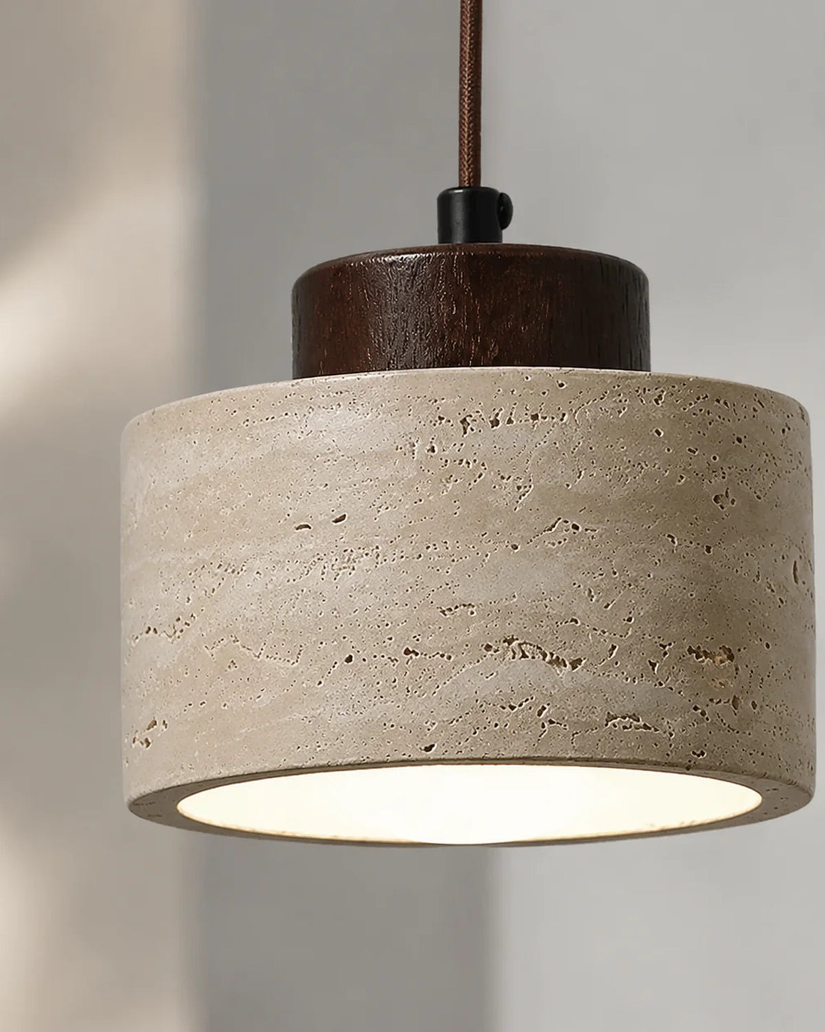 Detail van de travertijnen kap met natuurlijke poriën en warm licht | Maison Roze