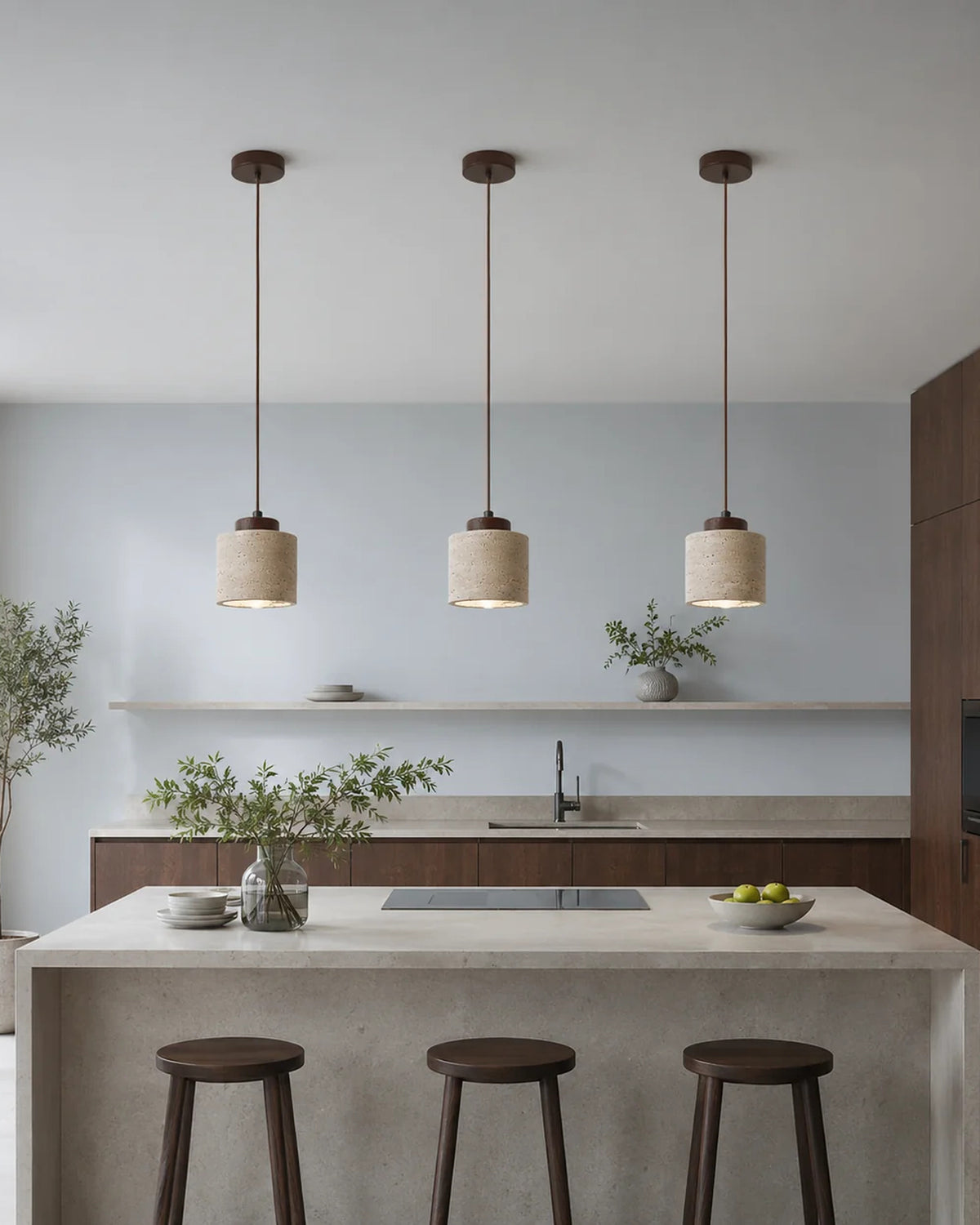 Drie travertin hanglampen boven een keukeneiland in een moderne keuken | Maison Roze